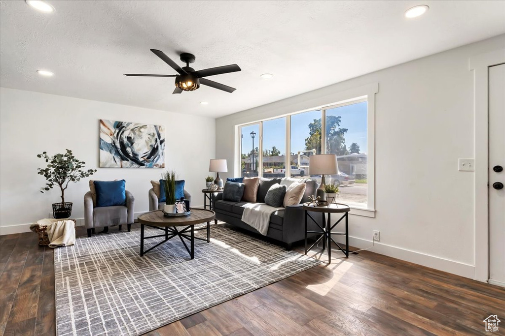 Living room featuring ceiling fan, dark hardwood / wood-style floors, and a textured ceiling