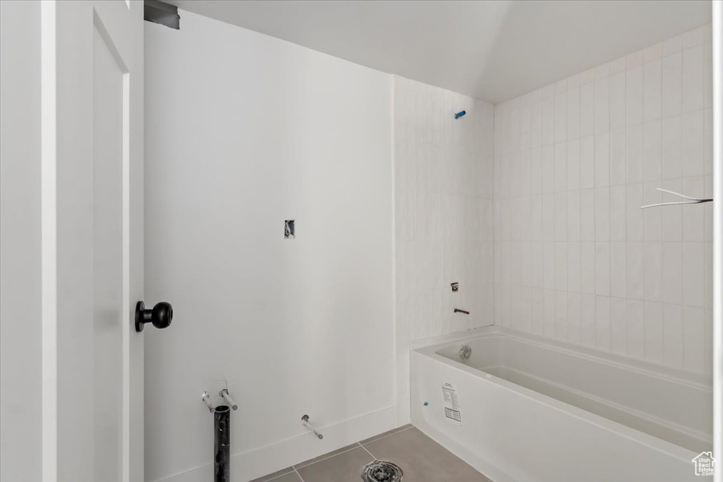 Bathroom with tiled shower / bath combo and tile patterned floors