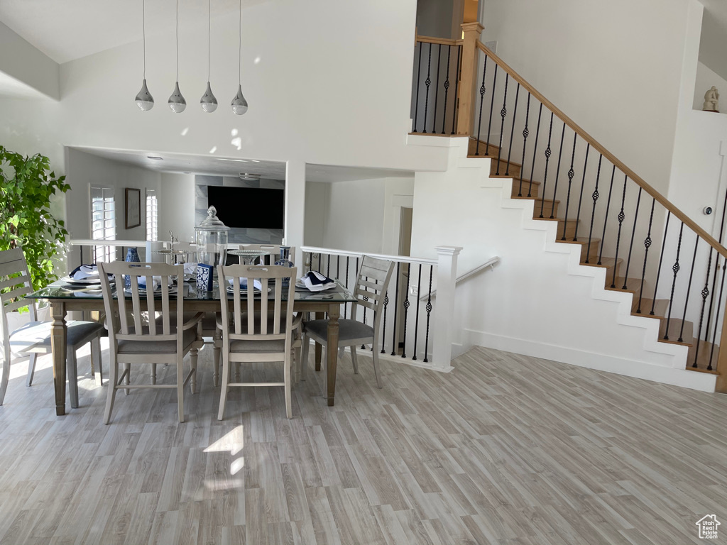 Dining space featuring light wood-type flooring and high vaulted ceiling