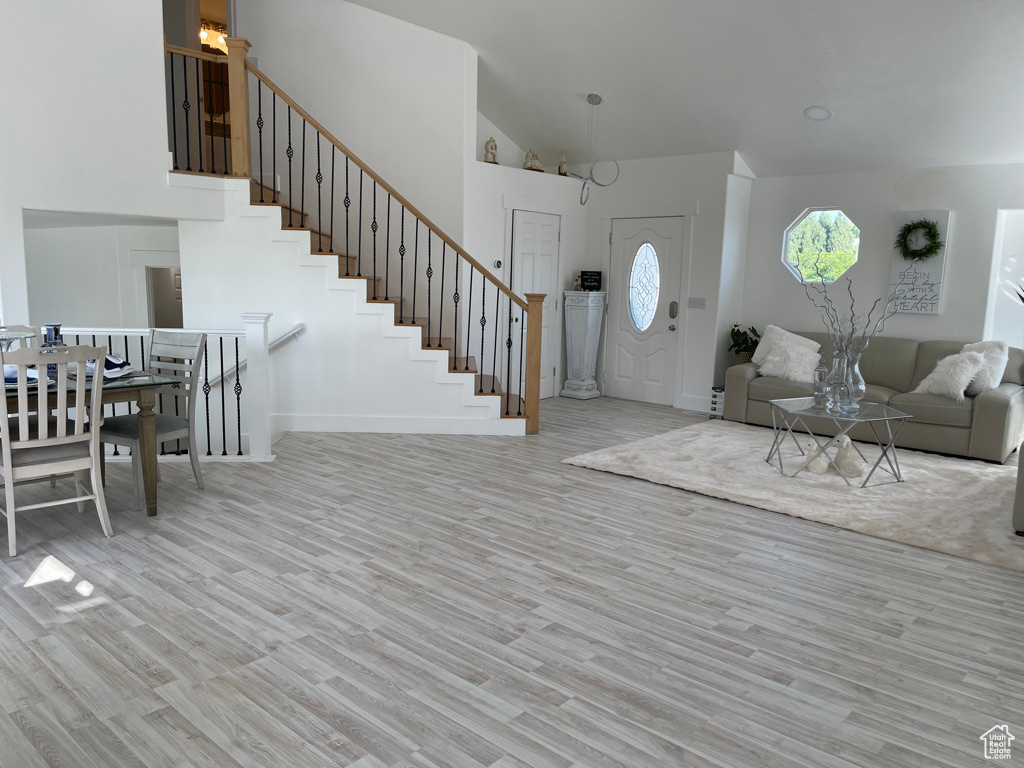 Living room with light hardwood / wood-style flooring and lofted ceiling