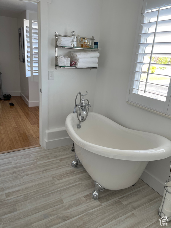 Bathroom featuring a tub to relax in and hardwood / wood-style floors