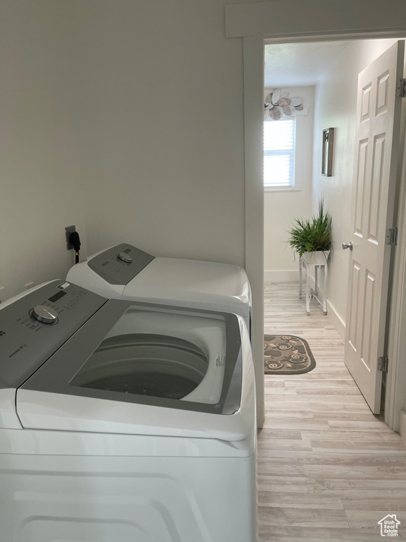 Washroom featuring light wood-type flooring and independent washer and dryer