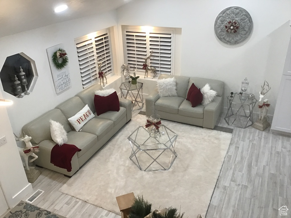 Living room featuring light wood-type flooring and lofted ceiling