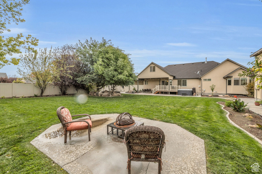 View of yard featuring a fire pit, a deck, and a patio area