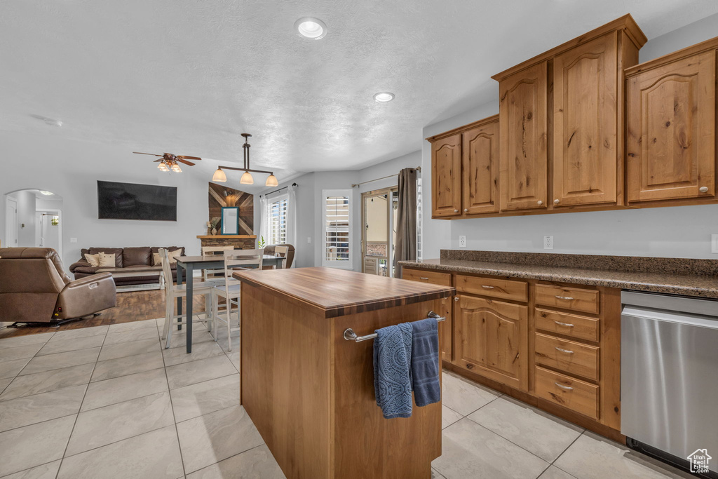 Kitchen with dishwasher, light tile patterned floors, a center island, ceiling fan, and decorative light fixtures