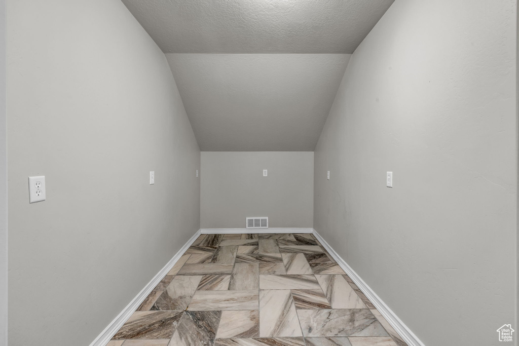 Laundry area with a textured ceiling and light parquet floors