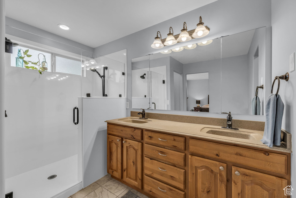 Bathroom featuring a shower with door and vanity