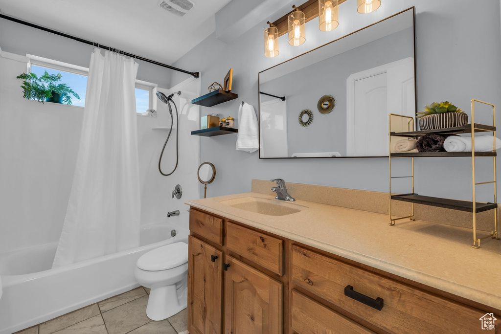 Full bathroom featuring shower / tub combo with curtain, tile patterned floors, vanity, and toilet