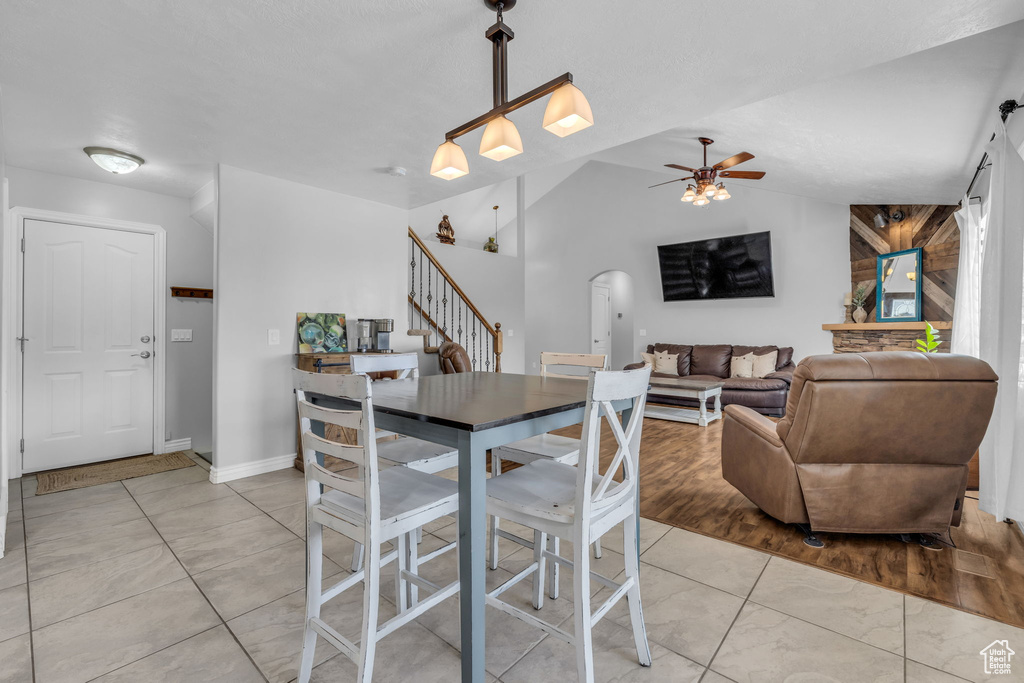 Dining area featuring ceiling fan, lofted ceiling, and light wood-type flooring