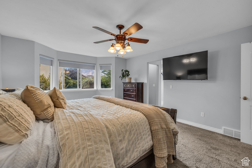 Carpeted bedroom featuring ceiling fan