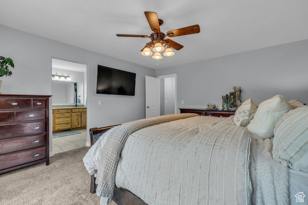 Carpeted bedroom with ceiling fan and ensuite bathroom