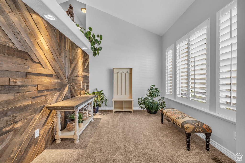 Sitting room featuring carpet flooring and wooden walls