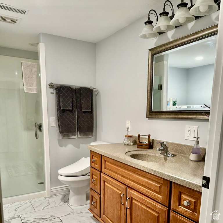 Bathroom with vanity, toilet, and a shower with door