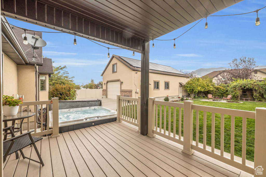 Wooden terrace with a lawn, an outdoor structure, and a garage