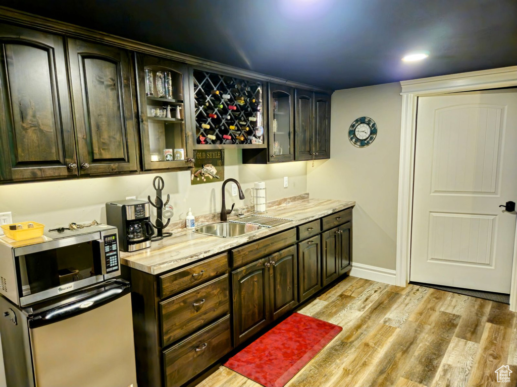 Kitchen featuring dark brown cabinets, light hardwood / wood-style floors, and sink