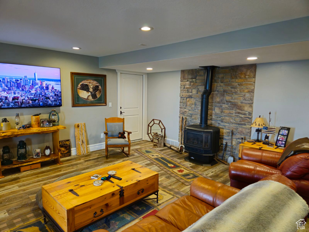 Living room with a wood stove and wood-type flooring