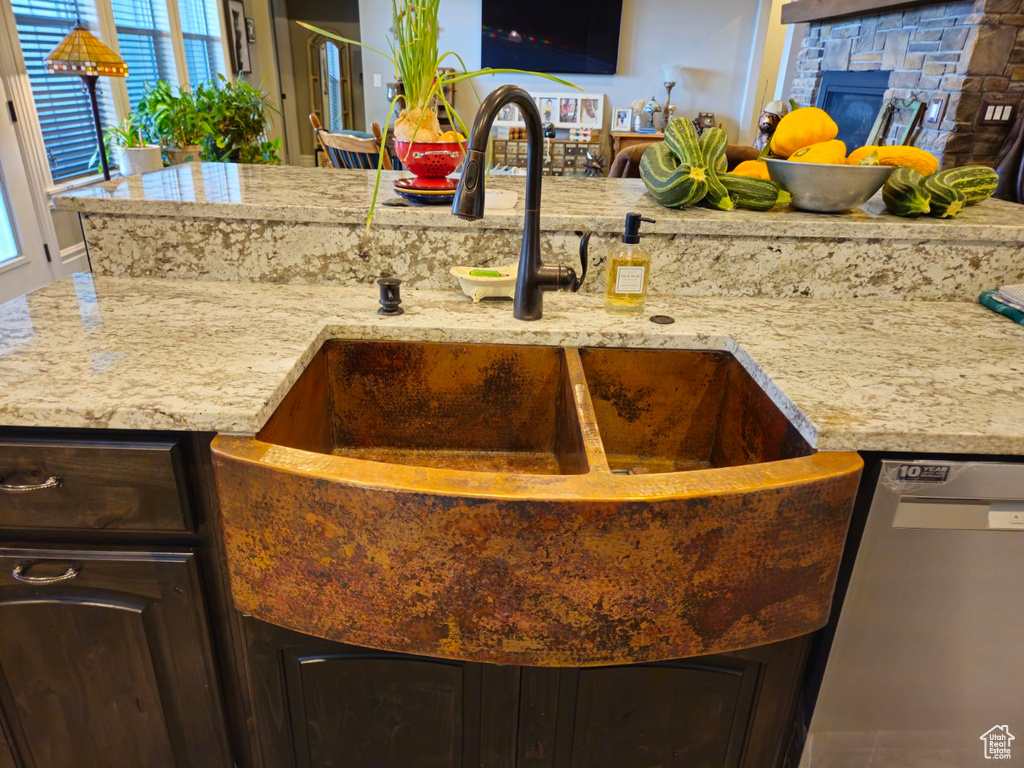 Details with dark brown cabinetry, stainless steel dishwasher, and sink