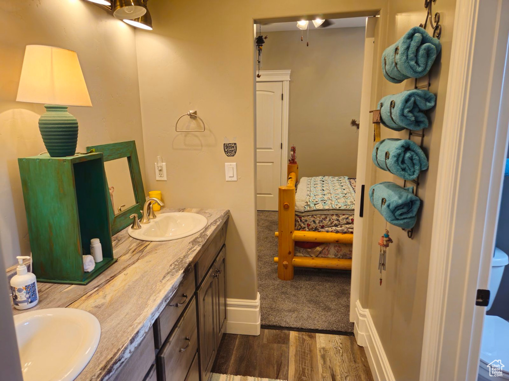 Bathroom featuring hardwood / wood-style flooring, vanity, and toilet