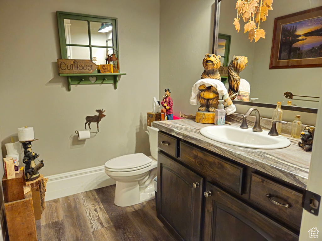 Bathroom featuring hardwood / wood-style floors, vanity, and toilet