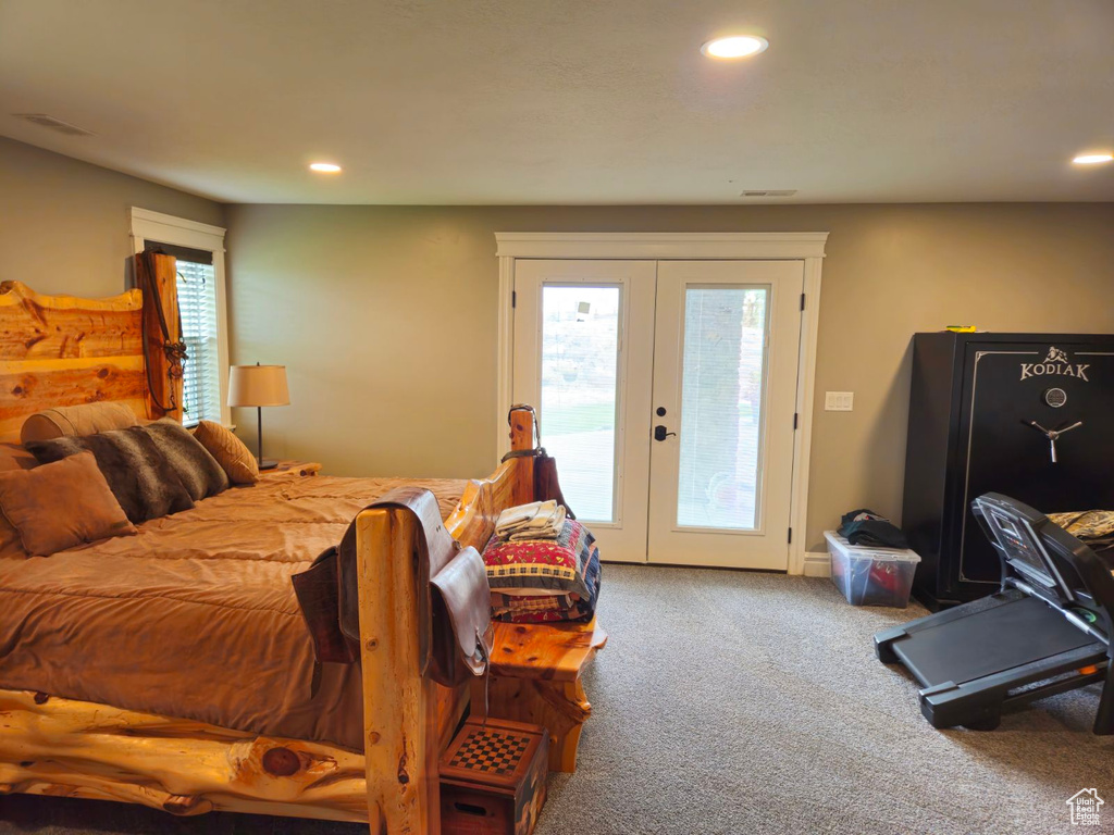 Carpeted bedroom featuring multiple windows, french doors, and access to exterior