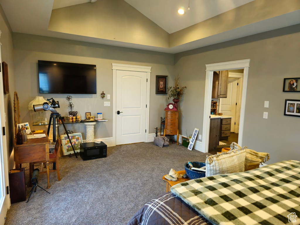 Bedroom with carpet floors, connected bathroom, and vaulted ceiling