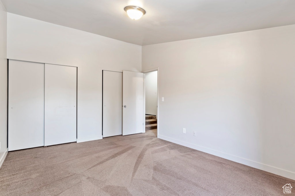 Unfurnished bedroom with light colored carpet