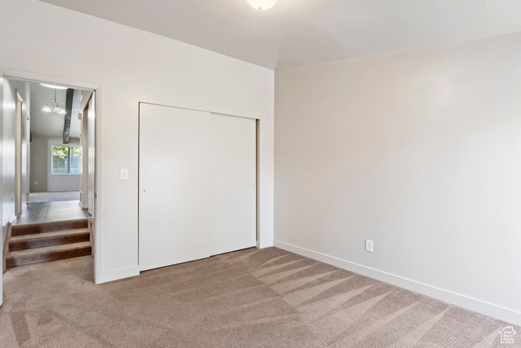 Unfurnished bedroom with carpet and a closet