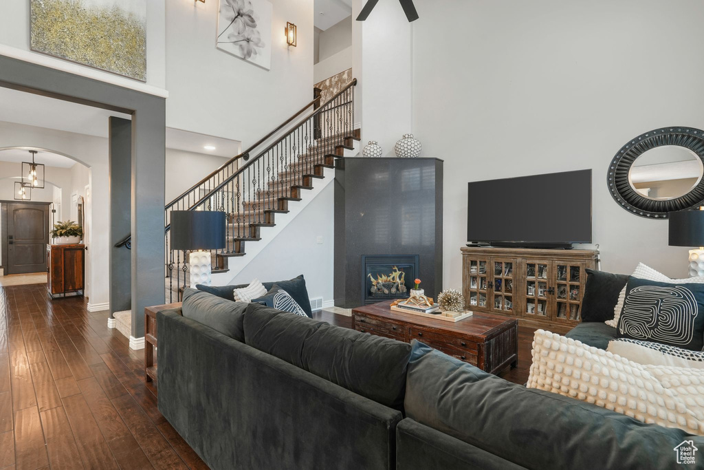 Living room with a towering ceiling and dark wood-type flooring