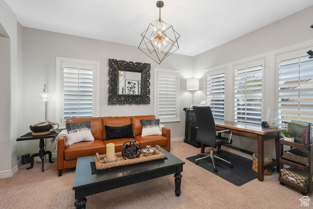 Home office with light carpet and an inviting chandelier