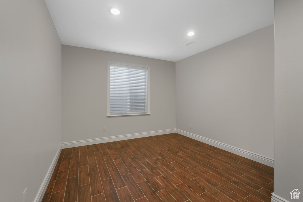 Spare room with dark wood-type flooring