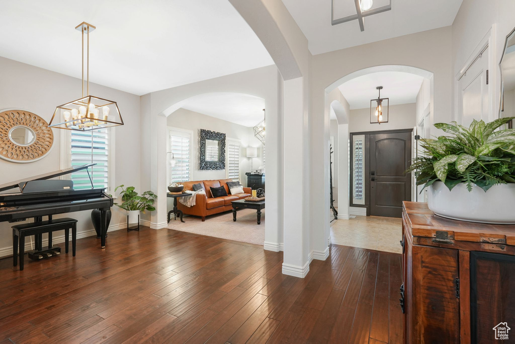 Foyer entrance with dark wood-type flooring and a chandelier