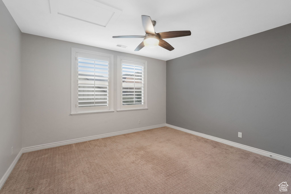 Empty room featuring ceiling fan and light colored carpet