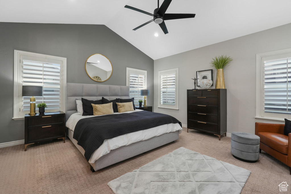 Carpeted bedroom featuring vaulted ceiling and ceiling fan