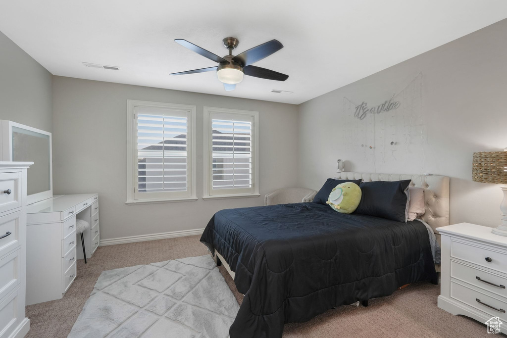 Carpeted bedroom featuring ceiling fan