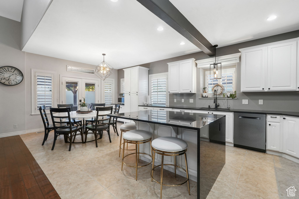 Kitchen with a wealth of natural light, decorative light fixtures, and stainless steel dishwasher