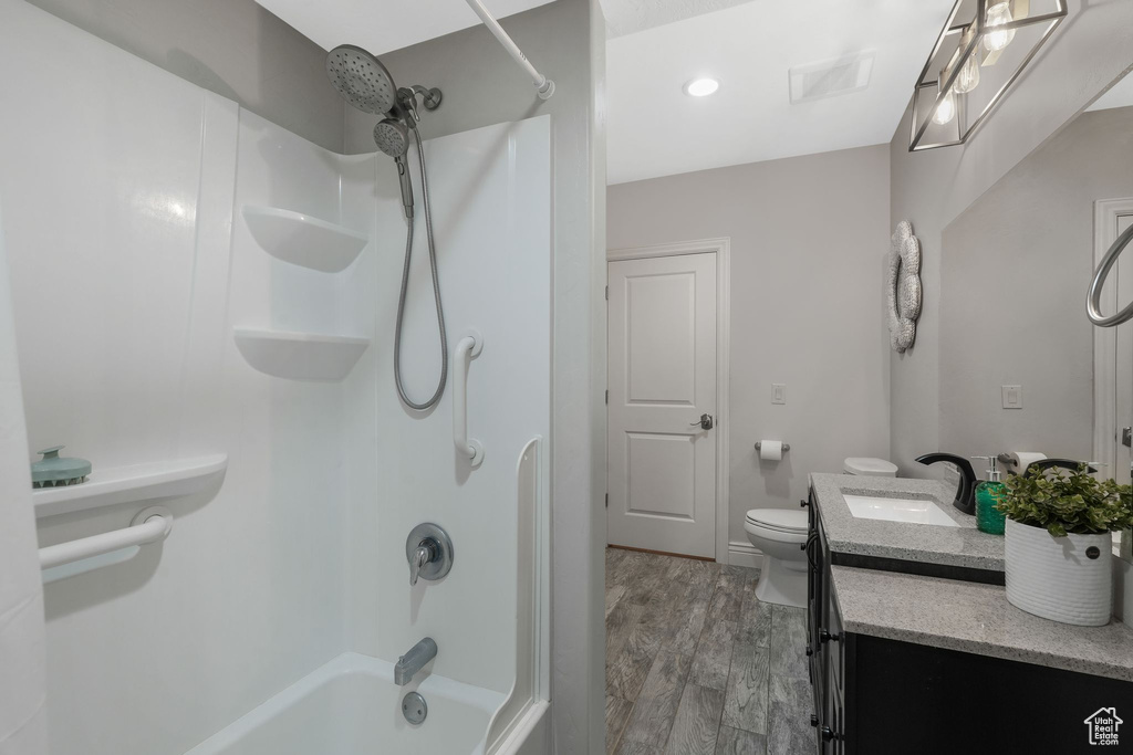 Full bathroom featuring bathtub / shower combination, hardwood / wood-style floors, vanity, and toilet