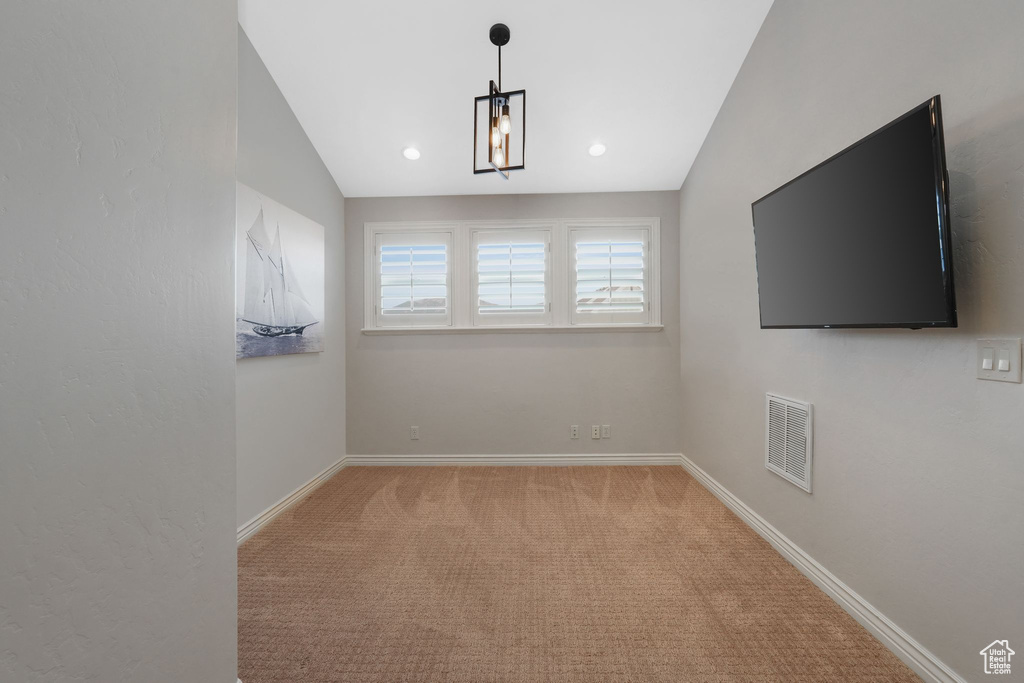 Carpeted empty room with vaulted ceiling