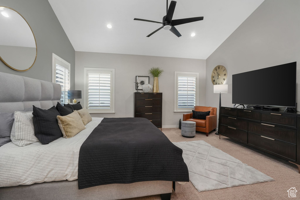 Carpeted bedroom featuring vaulted ceiling and ceiling fan