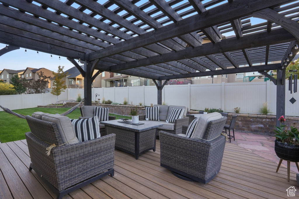 Wooden terrace with an outdoor hangout area and a pergola