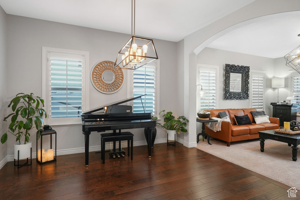 Interior space with dark wood-type flooring and a chandelier