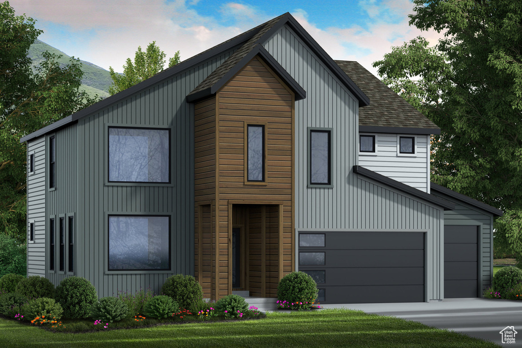 View of front of home featuring a front yard and a garage