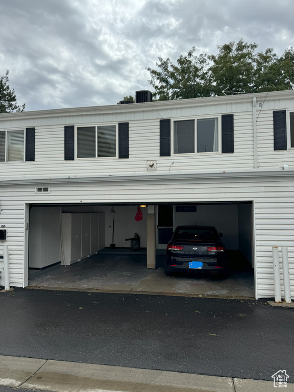 View of front of property featuring central AC unit and a garage