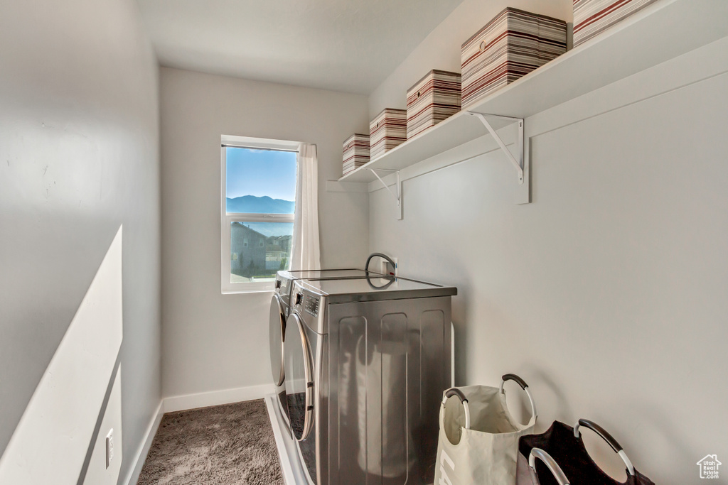 Clothes washing area featuring dark carpet and washer and clothes dryer