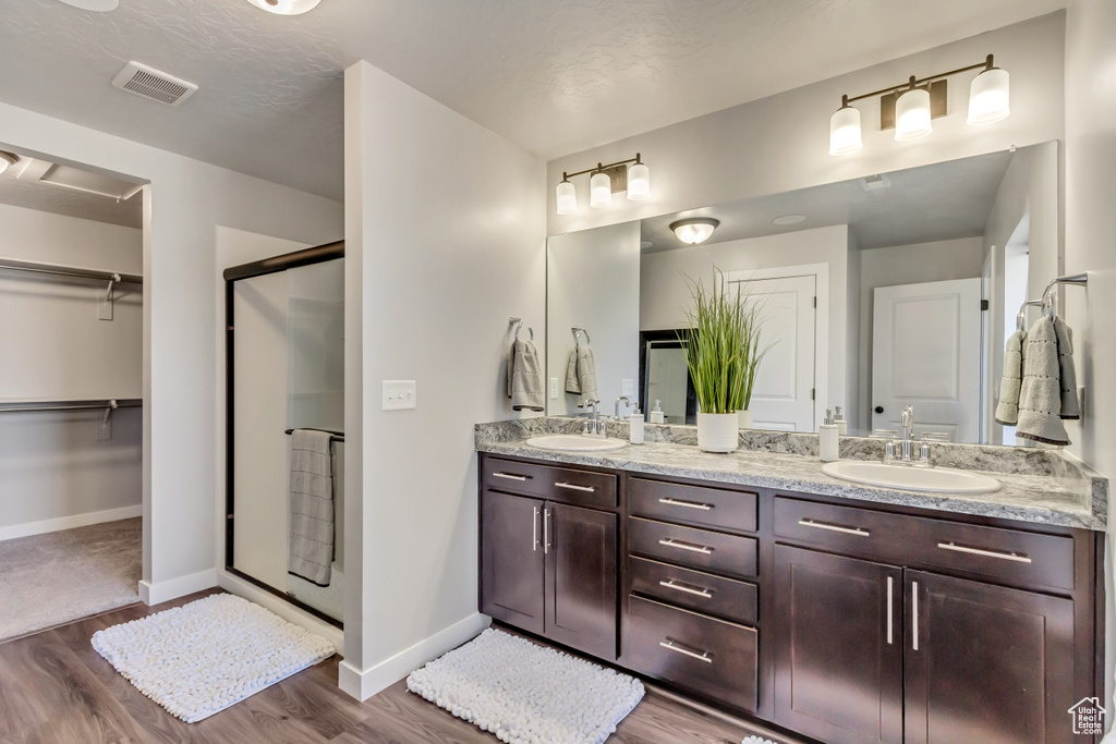 Bathroom with vanity, a textured ceiling, hardwood / wood-style flooring, and an enclosed shower