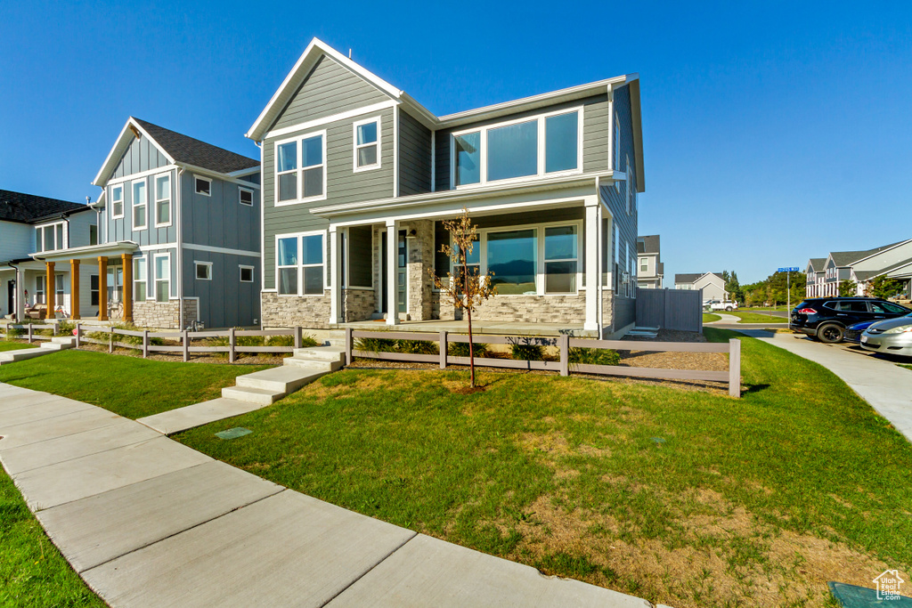 View of front of property with covered porch and a front lawn