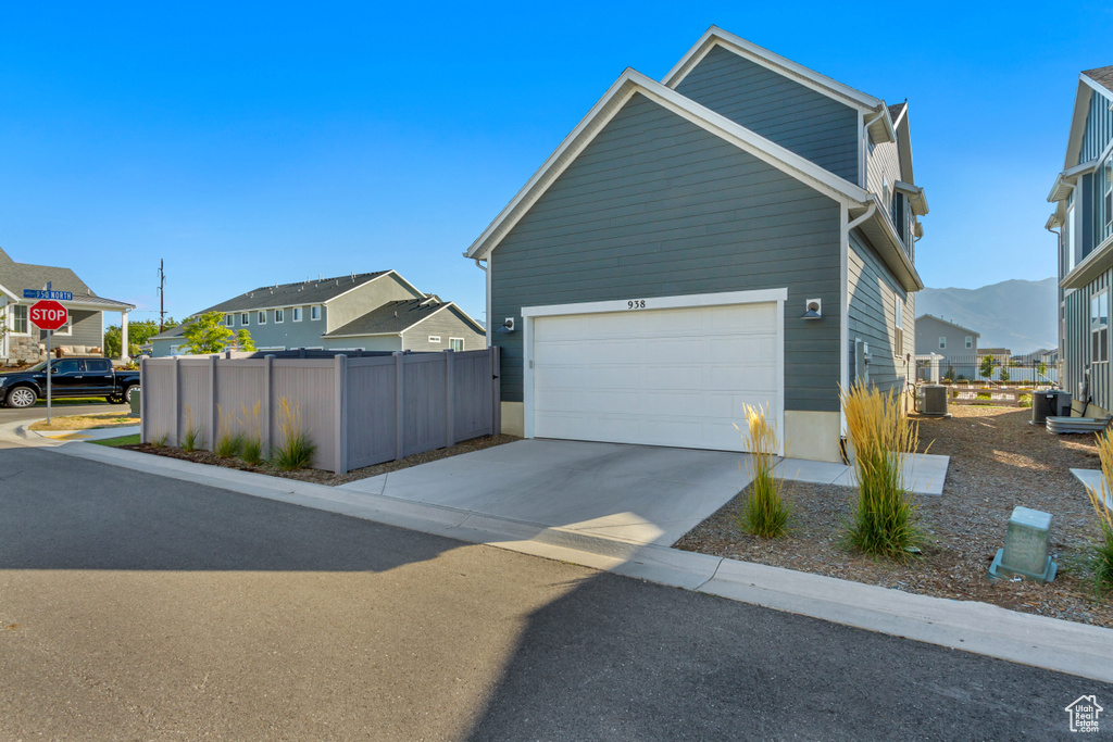 View of front of property featuring a garage, a mountain view, and central air condition unit