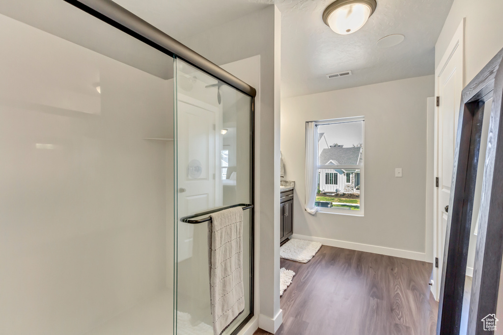 Bathroom featuring hardwood / wood-style floors, an enclosed shower, and vanity