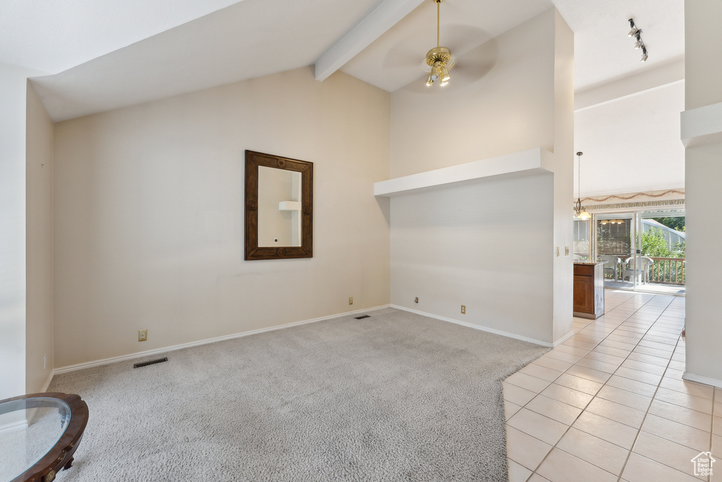 Spare room with ceiling fan, beamed ceiling, high vaulted ceiling, and light carpet