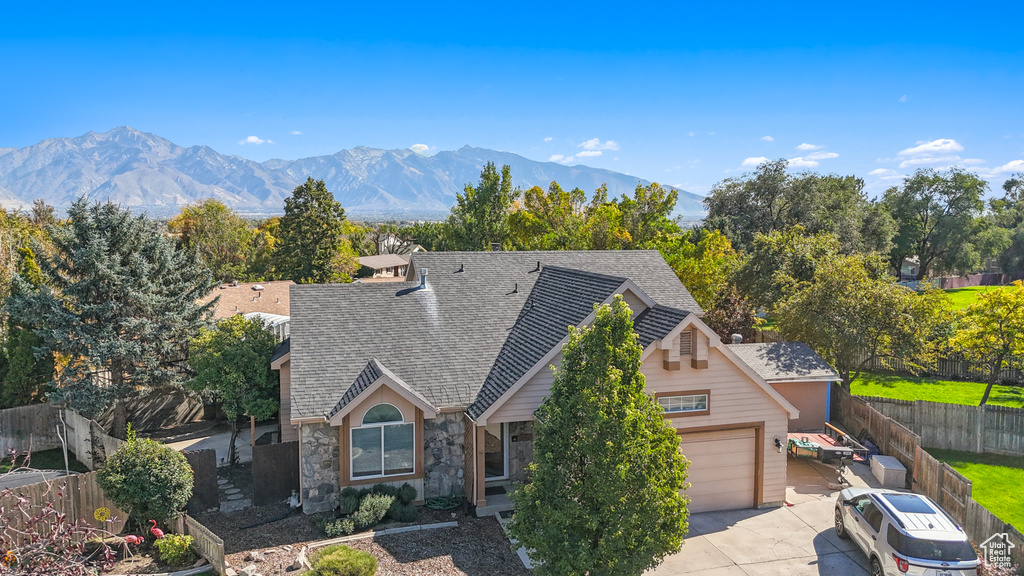 View of front of property with a mountain view and a garage