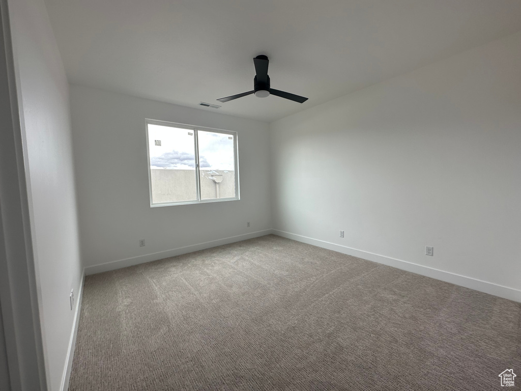 Carpeted spare room with ceiling fan